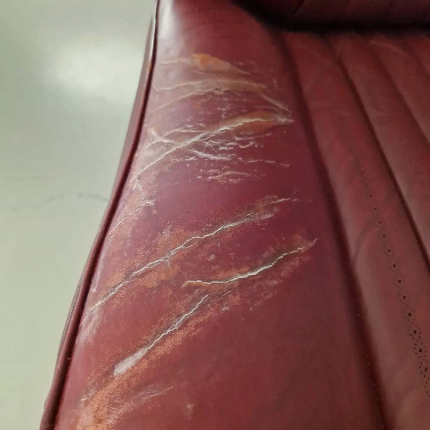 Sedile rosso screpolato prima del restauro